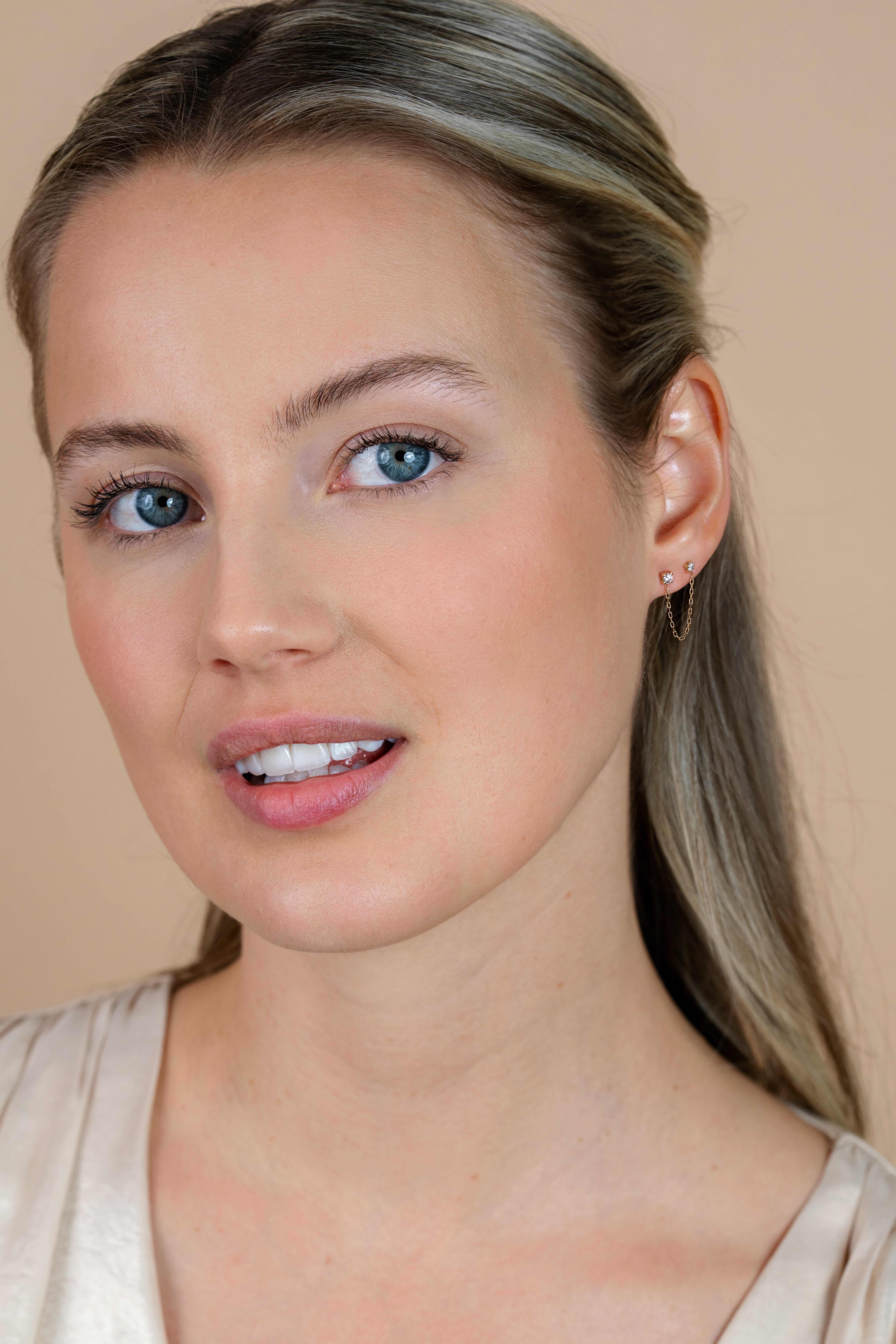 35mm ZINZI Gold 14 krt gouden dubbele oorstekers met verbonden ketting en witte zirkonia. Maar voor één oor. ZGO547 
