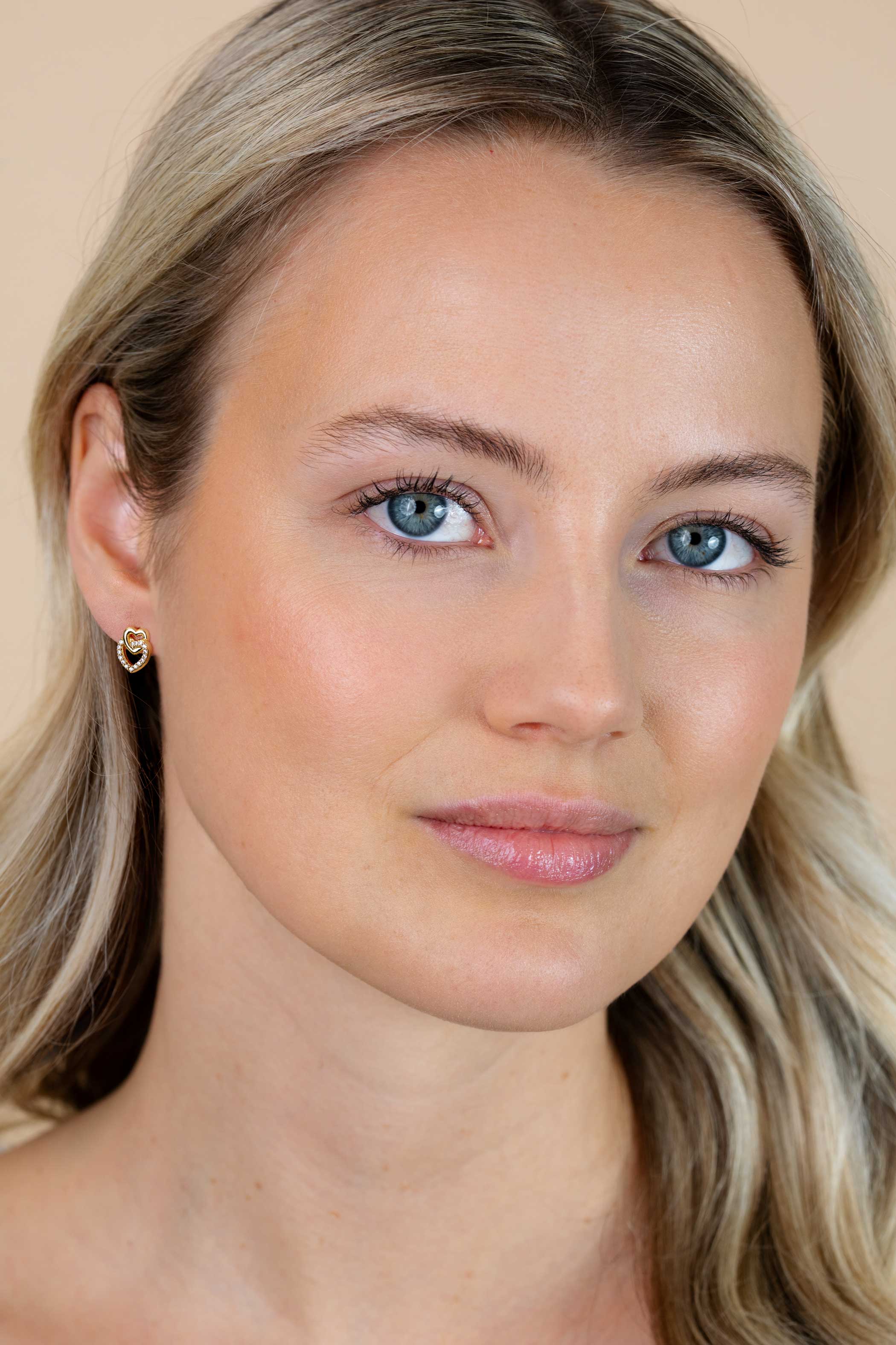 10mm ZINZI gold plated zilveren oorknoppen 2 open hartjes met elkaar verbonden, waarvan 1 hartje bezet met witte zirconia's ZIO2493Y