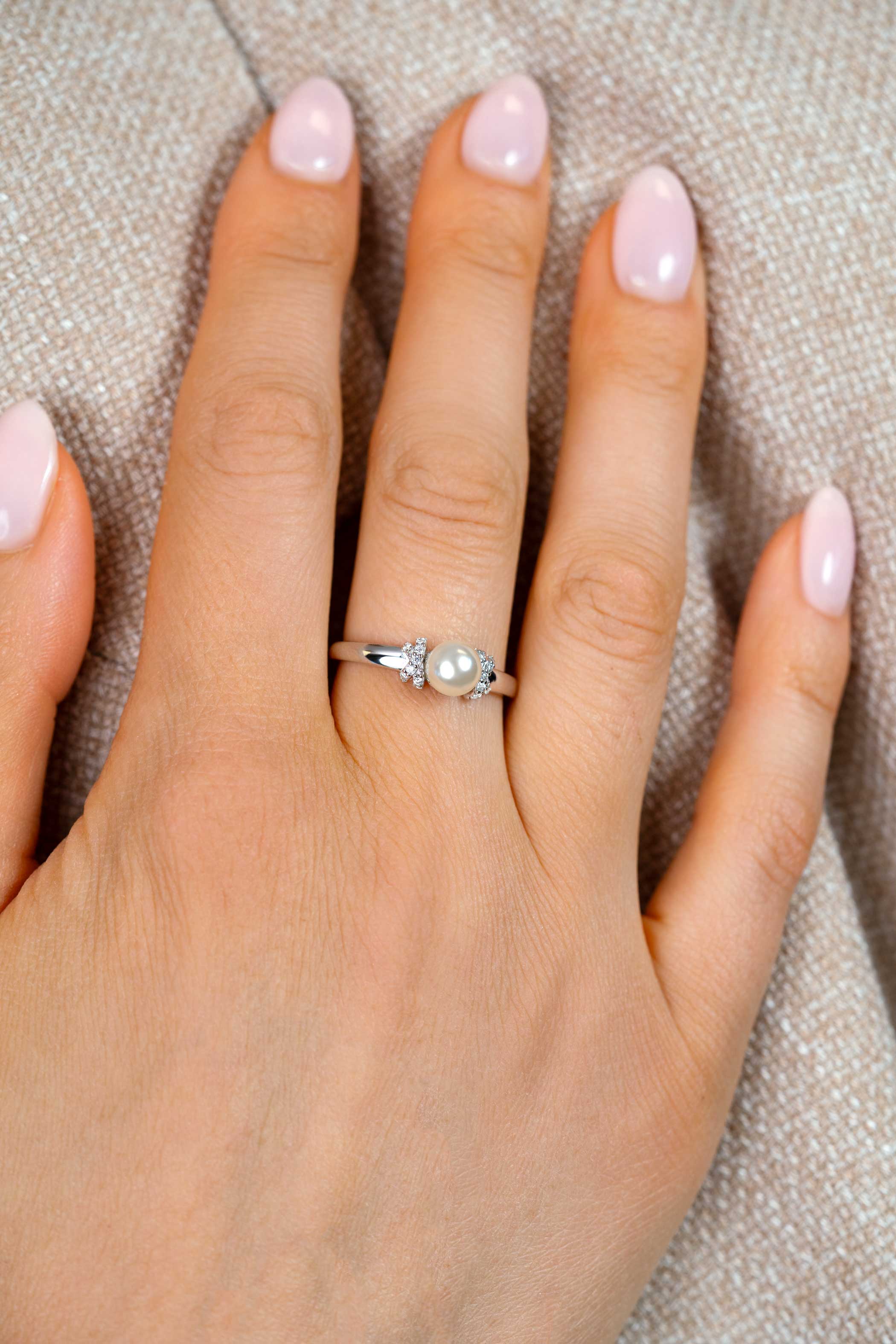 ZINZI zilveren ring met een witte parel (6mm), aan weerszijden subtiel bezet met witte zirkonia's in een strikvormige zetting ZIR2863