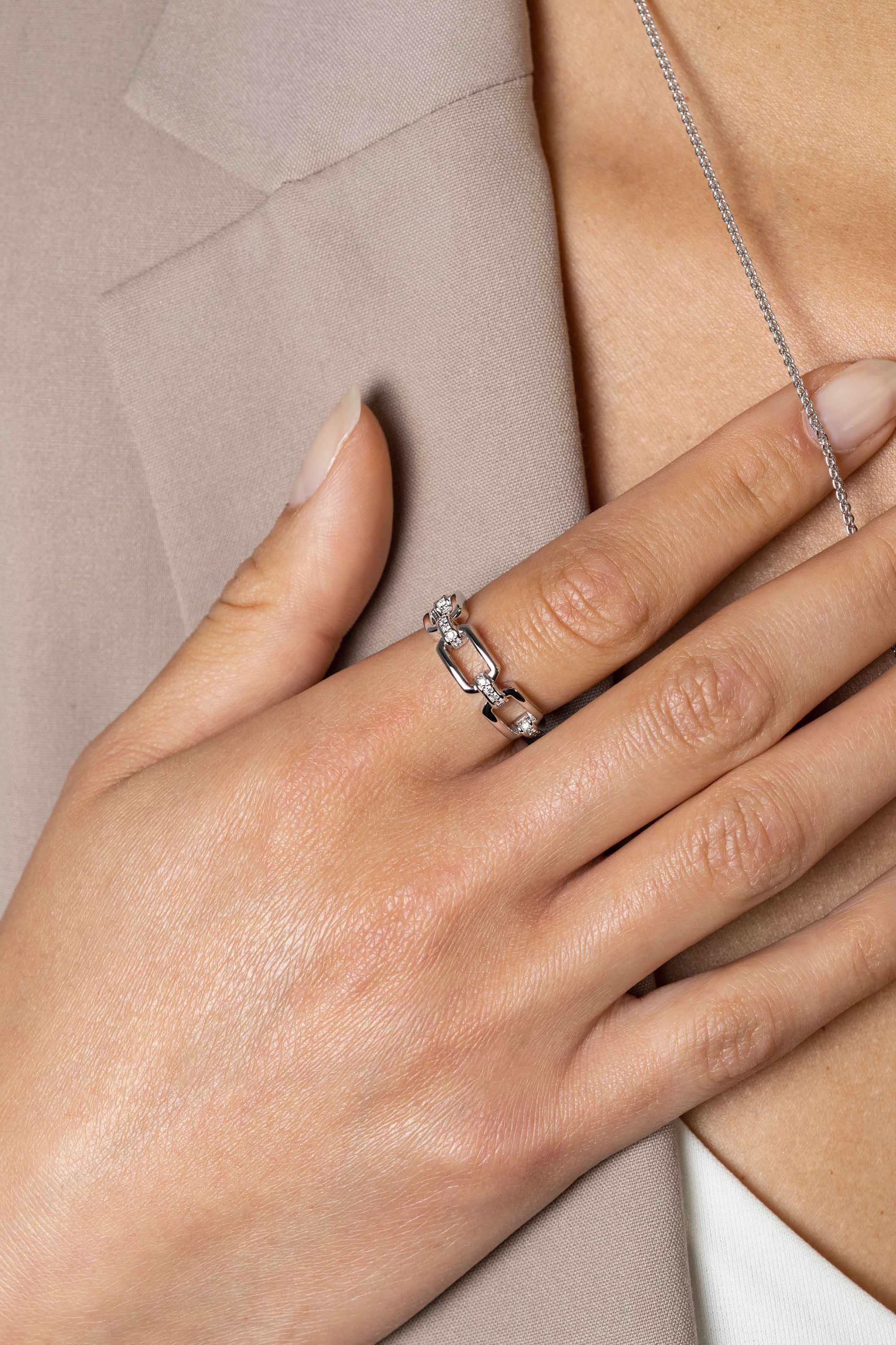 ZINZI zilveren stoere schakelring (6mm breed) waarbij drie rechthoekige schakels sierlijk met elkaar zijn verbonden. De verbinding-schakels zijn bezet met witte zirconia's ZIR2494C