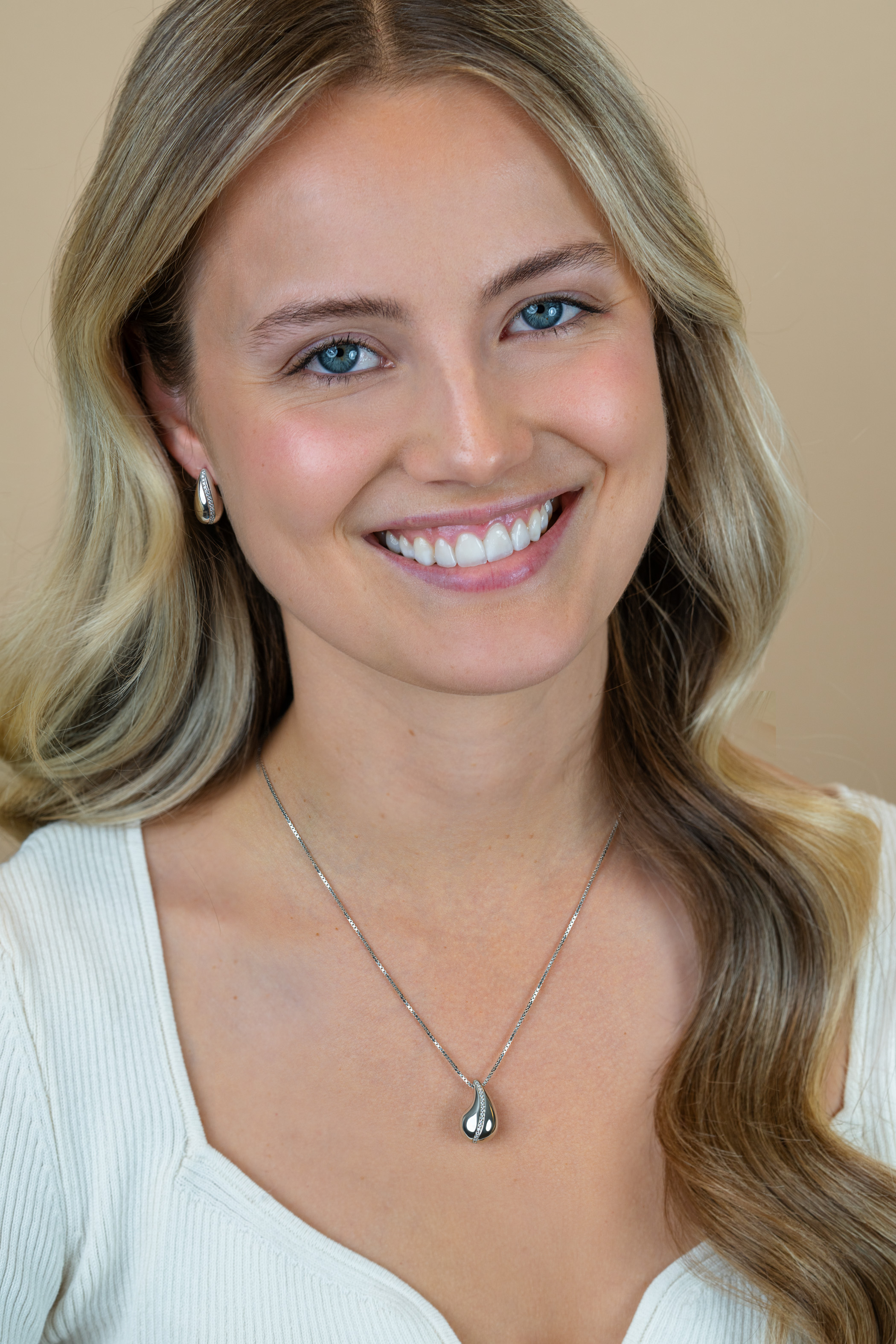 17mm ZINZI zilveren oorstekers in druppelvorm met golvende rij witte zirkonia's ZIO2707