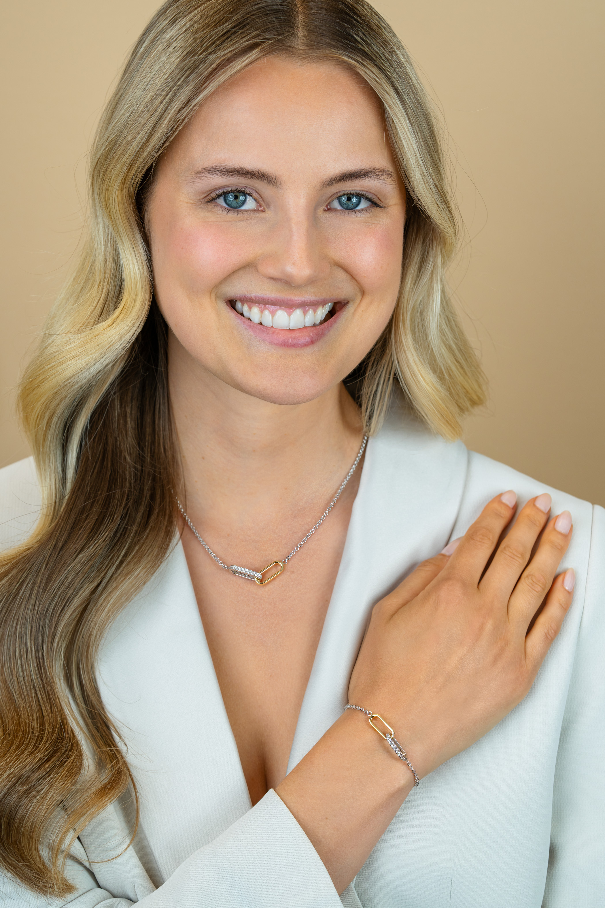 ZINZI zilveren schakelarmband met twee verbonden ovale schakels: ene gold plated, ander bezet met witte zirkonia's ZIA2758