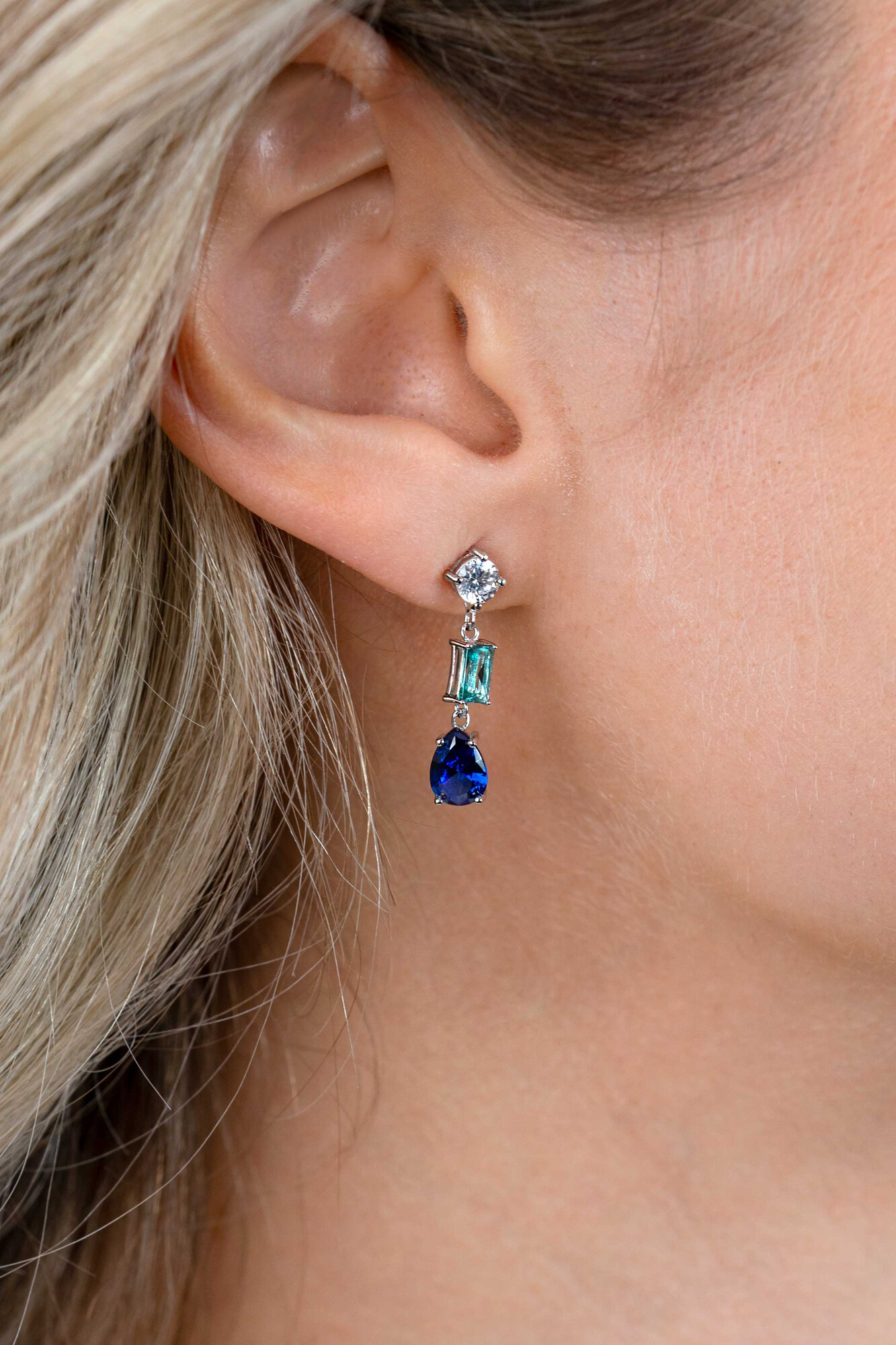 ZINZI zilveren lange oorsieraden 29mm met een prachtige combinatie van blauwe kleurstenen. In vierkant, ovaal en peervorm, afgewisseld met kleine witte zirconia's. ZIO2397