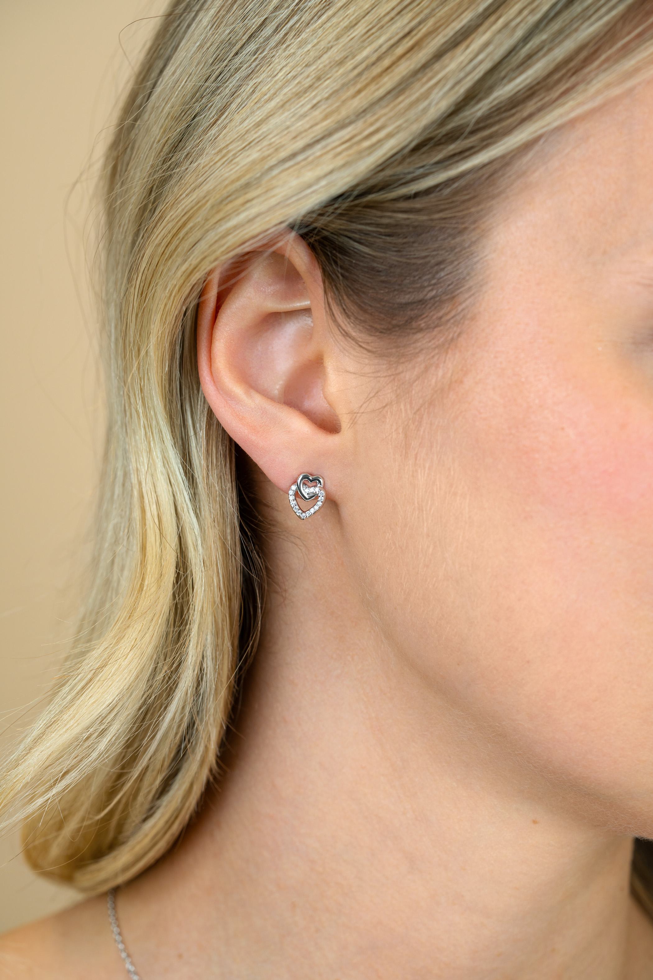 10mm ZINZI zilveren oorknoppen 2 open hartjes met elkaar verbonden, waarvan 1 hartje bezet met witte zirconia's ZIO2493