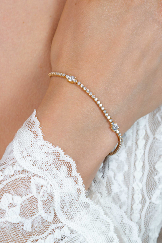 ZINZI gold plated zilveren tennisarmband 2,1mm breed bezet met witte zirkonia’s in verfijnde rijzetting, afgewisseld met drie grotere witte zirkonia's (4,3mm) in chatonzetting ZIA2894Y