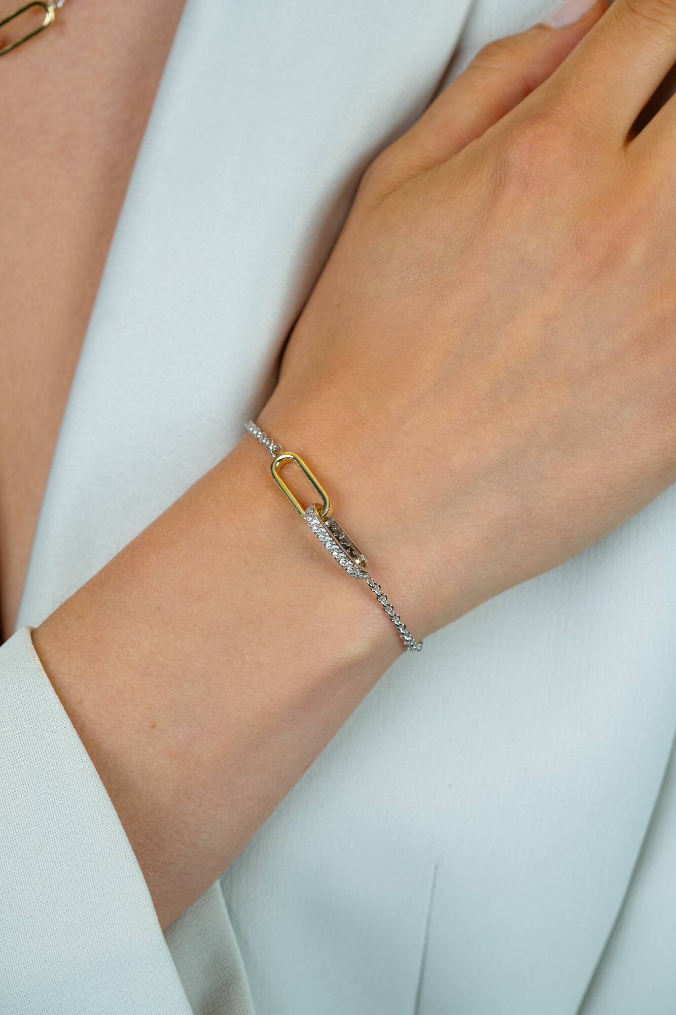 ZINZI zilveren schakelarmband met twee verbonden ovale schakels: ene gold plated, ander bezet met witte zirkonia's ZIA2758
